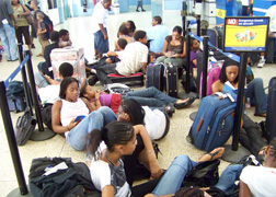 LIAT passengers sit on the floor at the E.T. Joshua airport two weeks ago while waiting almost 24 hours for a flight. 