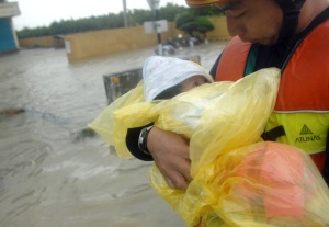 A man carries a baby as a family is rescued from flooding brought by Typhoon Morakot in Chiatung, Pingtung county, in southern Taiwan, on August 9, 2009. (PATRICK LIN/AFP/Getty Images)