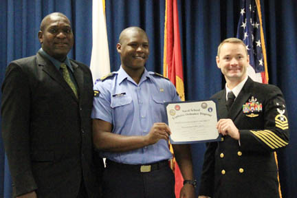 Acting Commander of the Coast Guard, Brenton Cain, left, AB Damian Franklyn, centre, flanked by a member of the United States Naval Ordnance Disposal School.